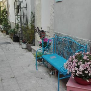 una panchina blu seduta accanto a un edificio con fiori di Only for two Giumbabulla a Ragusa
