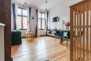 sala de estar con sofá y mesa con sillas en Best 2 Rest Apartment, en Toruń