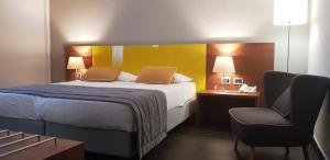 Pokój hotelowy z łóżkiem i krzesłem w obiekcie Hotel Sandalia w mieście Nuoro