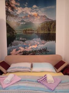 - un lit avec des oreillers et un tableau mural dans l'établissement Dado, à Bijeljina