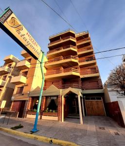 a tall building with a sign in front of it at Patagonia Apart Hotel in Puerto Madryn