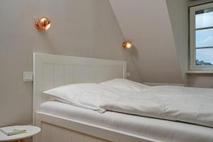 a bedroom with a white bed and a window at Yellow-Upmarine in Westerland (Sylt)