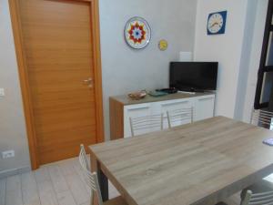 a dining room with a table and a television at casa francesca in Castellammare del Golfo