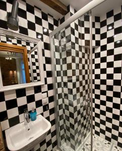 a bathroom with a sink and a shower with checkered tiles at My place in Poznan in Poznań