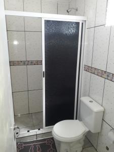 uma casa de banho com um WC e uma porta de duche em vidro. em Alojamiento 1 Lili y Víctor em Puerto Iguazú