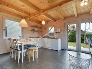 a kitchen and dining room with a table and chairs at Ciche Wydmy in Sasino