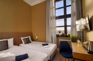 sypialnia z 2 łóżkami, biurkiem i oknem w obiekcie Apartamenty Oliwka w Elblągu