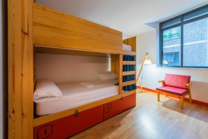 a bunk bed in a room with a chair and a window at Ok Hostel Madrid in Madrid