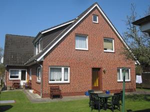 ein rotes Backsteinhaus mit einem Tisch im Hof in der Unterkunft Wohnung Lund 2 in Wyk auf Föhr
