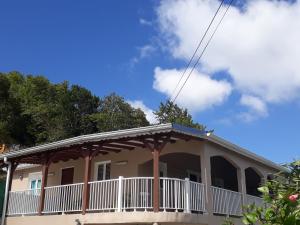 a house with a porch on top of it at Villa les Alizés in Les Anses-dʼArlets