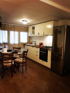kuchnia z białymi szafkami, stołem i lodówką w obiekcie Apartment Zagy Blue w Zagrzebiu