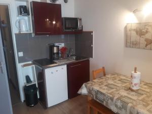 a small kitchen with a table and a counter top at Studio les deux alpes Résidence le Pluton B84 WIFI in Les Deux Alpes