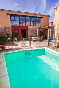 a swimming pool in front of a house at Casa Rural El Cartero in Carpio de Azaba