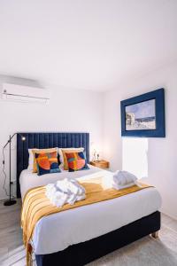 um quarto com uma cama grande com almofadas laranja e azul em BBA Apartments Palácio I - Douro View & Parking no Porto