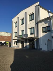 a large white building with a sign on it at Pension Dreilinden Hannover GmbH in Hannover