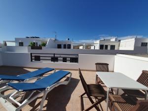 eine Terrasse mit Stühlen und Tischen auf dem Dach in der Unterkunft Apartamentos Graciosamar in Caleta de Sebo