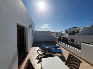 a balcony with chairs and tables on a building at Apartamentos Graciosamar in Caleta de Sebo