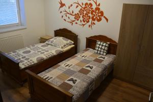 a bedroom with two twin beds and a clock on the wall at Dentissimi vendégszobák in Mosonmagyaróvár