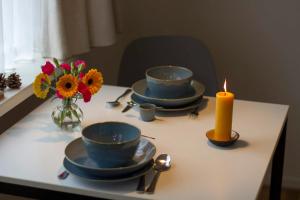 una mesa con cuatro cuencos y una vela y flores en Studio Zonnehoek Schoorl, en Schoorl