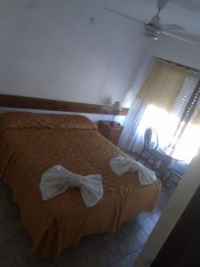 Un dormitorio con una cama con arcos. en Hotel Las 40 en Villa Gesell