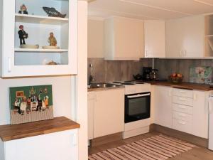 una cocina con armarios blancos y fregadero en Holiday home HARPLINGE II en Harplinge