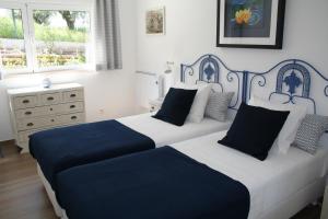 a bedroom with two beds with blue and white at Encosta da Camarinha in Ferreira do Zêzere
