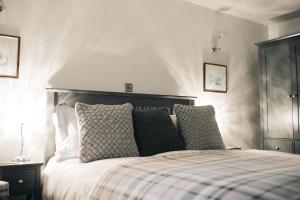 a bedroom with a bed with pillows on it at Saddleworth Holiday Cottages in Oldham