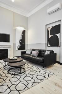 a living room with a black couch and a table at SERRANO GOLDEN MILE II, by Presidence Rentals in Madrid