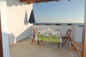 un tavolo e sedie su un balcone con vista sull'oceano di SENAFER Funtana Meiga a Funtana Meiga