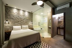 ein Schlafzimmer mit einem Bett und einer ebenerdigen Dusche in der Unterkunft Villa Ayê Socorro SP - Pousada Petfriendly in Socorro + 50 Fotos