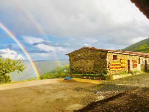 Negreda的住宿－Mosteirinho，天上方的彩虹在石头建筑上