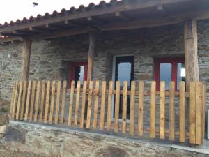 a wooden fence in front of a stone house at Mosteirinho in Negreda