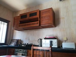 cocina con armarios de madera y encimera en Residence Les Calanques en Dakar