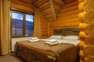 - une chambre avec un lit dans une cabane en rondins dans l'établissement Eco Hotel Bungalo, à Bukovel