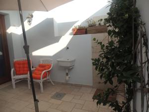 a bathroom with a toilet and a chair and an umbrella at SENAFER Funtana Meiga in Funtana Meiga
