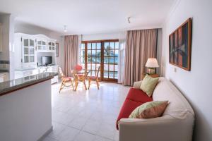 a living room with a couch and a kitchen at Playa Delphin in Puerto Naos