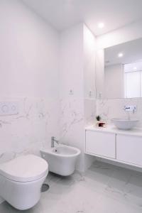 bagno bianco con servizi igienici e lavandino di BBA Apartments Palácio II - Garden View & Parking a Porto