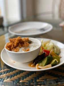 un tazón de comida en un plato con arroz y verduras en Cheng-Ping Hot Spring Inn en Wenquan