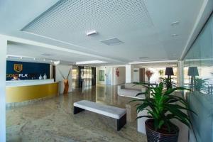 a lobby with two benches and a potted plant at Gold Flat Cabo Branco in João Pessoa