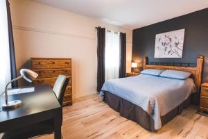 a bedroom with a bed and a desk and a desk at Hotel Le Plaza in La Baie