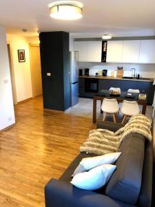 a living room with a couch and a kitchen at Clotes modern apartment, 50m from slopes - sleeps 6-8, 2 bath - SauzeHoliday in Sauze dʼOulx