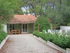 uma pequena casa verde com uma mesa em frente em Comfortable holiday home with private pool em Fayence