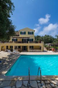 a villa with a swimming pool in front of a house at Villa Elaia Suites & Apartments No.3 in Gaios