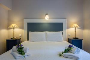 a bedroom with a bed with towels and flowers on it at Villa Elaia Suites & Apartments No.3 in Gaios