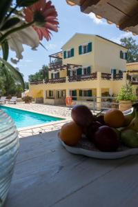 a plate of fruit on a table next to a pool at Villa Elaia Suites & Apartments No.3 in Gaios