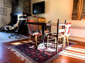 sala de estar con mesa, sillas y chimenea en Relais Borgo Poggetello, en Tagliacozzo