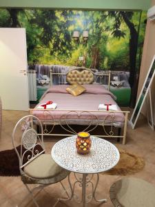 B&B la reggia في كازيرتا: غرفة نوم بسرير وطاولة وكراسي