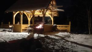 Eine Person steht vor einem Feuer im Schnee in der Unterkunft Pod Hawraniem Ski & Bike Friendly in Jurgów