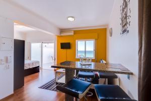 Una cocina con paredes amarillas y una mesa con sillas. en Sky - wonderful view to the beach - Quarteira, en Quarteira