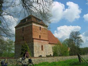 a large brick building with a person sitting in front of it at Kleine Auszeit - Natur und Erholung in Mecklenburg in Reimershagen